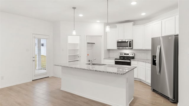 kitchen featuring white cabinetry, a kitchen island with sink, pendant lighting, and stainless steel appliances