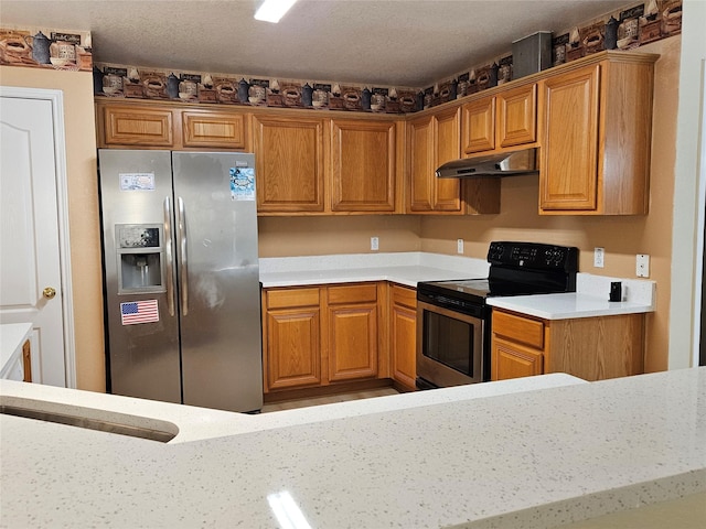 kitchen featuring light stone counters, a textured ceiling, and appliances with stainless steel finishes