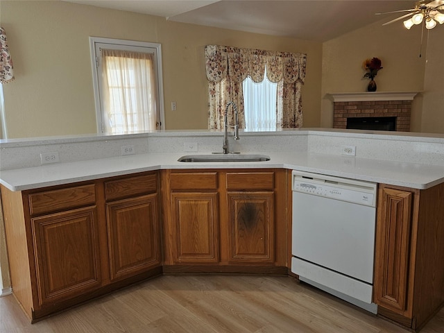 kitchen with sink, vaulted ceiling, light hardwood / wood-style flooring, dishwasher, and ceiling fan