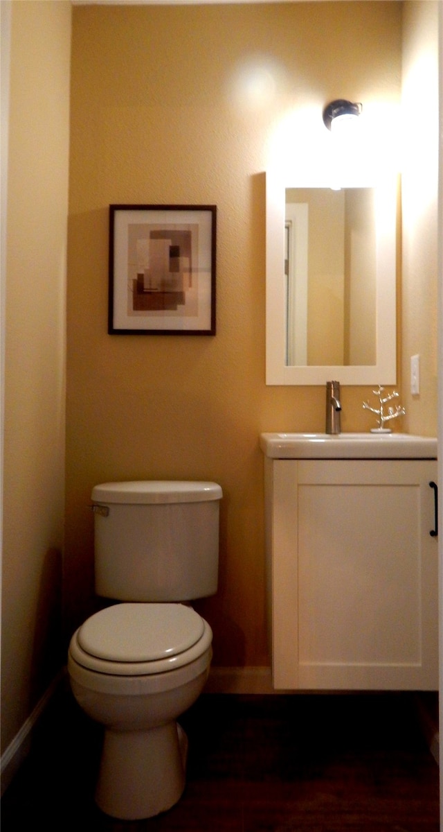 bathroom with hardwood / wood-style flooring, vanity, and toilet