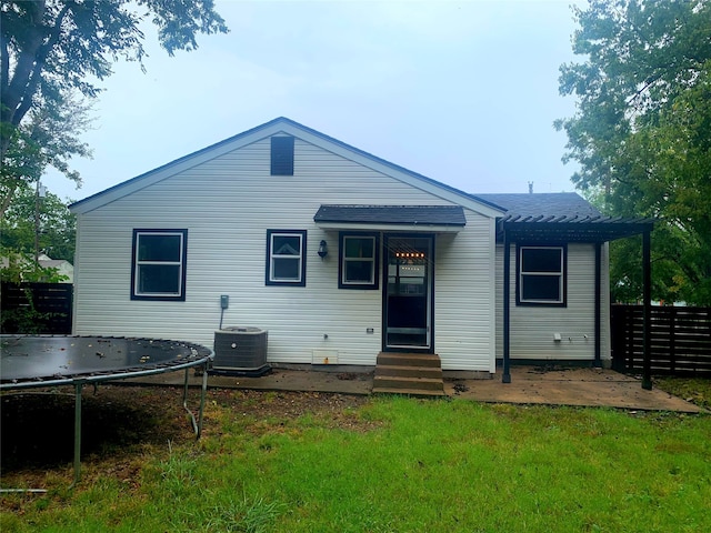 back of house with a yard, a trampoline, a patio, and cooling unit