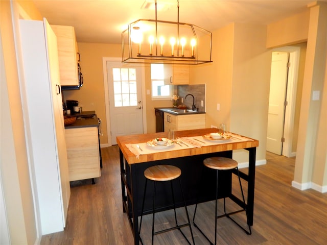 kitchen featuring dishwasher, sink, dark hardwood / wood-style floors, a kitchen island, and butcher block counters