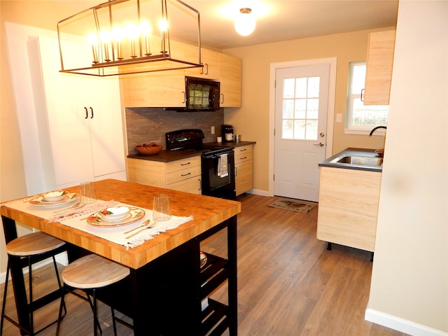 kitchen with decorative backsplash, sink, black appliances, light brown cabinets, and hardwood / wood-style floors