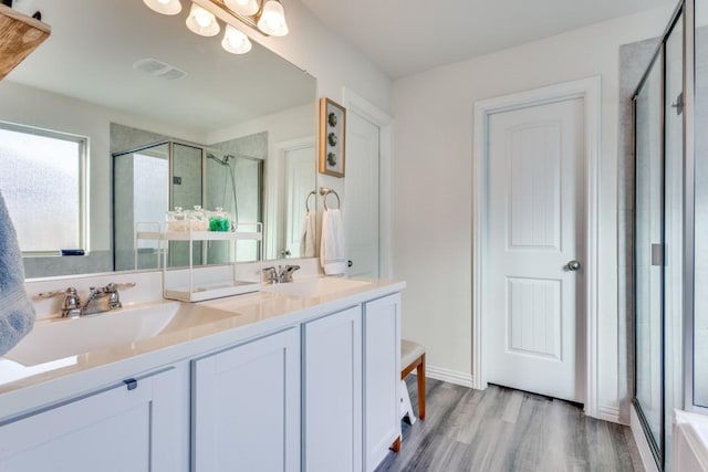 bathroom featuring hardwood / wood-style floors, vanity, and an enclosed shower