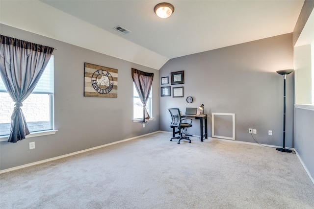 carpeted home office featuring vaulted ceiling