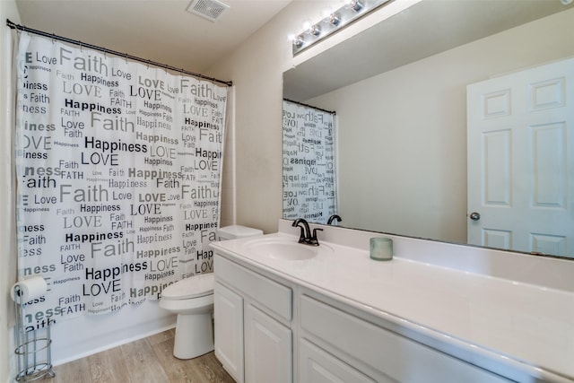 full bathroom with shower / bathtub combination with curtain, hardwood / wood-style floors, vanity, and toilet