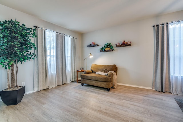 living area with plenty of natural light and light hardwood / wood-style floors