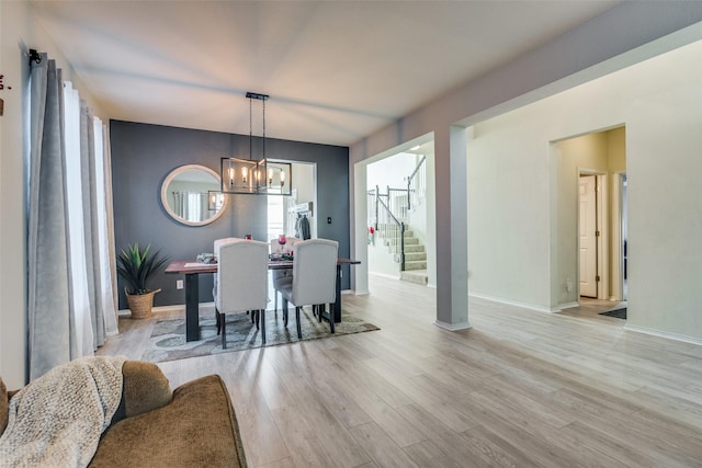 dining area with an inviting chandelier and light hardwood / wood-style flooring