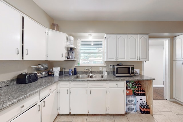 kitchen with white cabinetry, sink, and light tile patterned floors