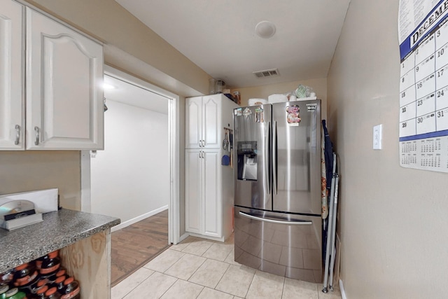 kitchen featuring stainless steel fridge, white cabinetry, and light hardwood / wood-style flooring