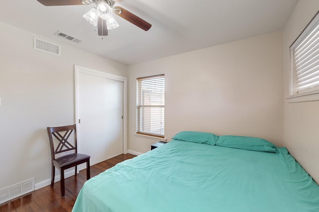 bedroom with dark hardwood / wood-style flooring, a closet, and ceiling fan