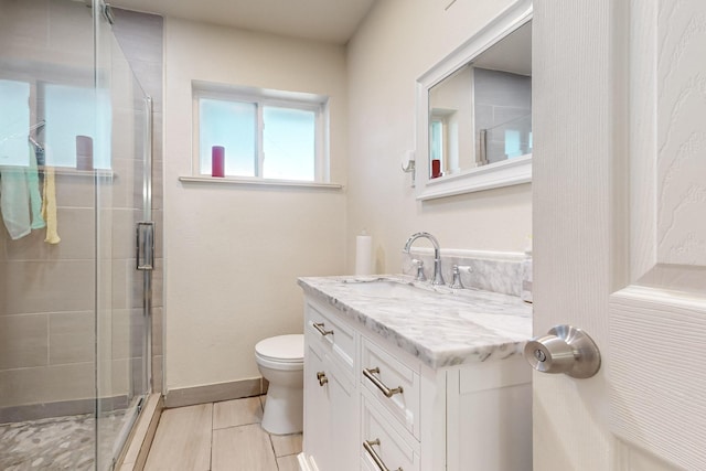 bathroom featuring tile patterned floors, vanity, toilet, and an enclosed shower