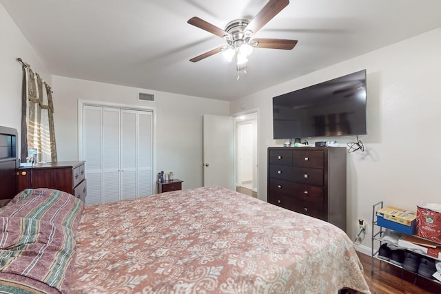 bedroom featuring dark hardwood / wood-style flooring, ceiling fan, and a closet