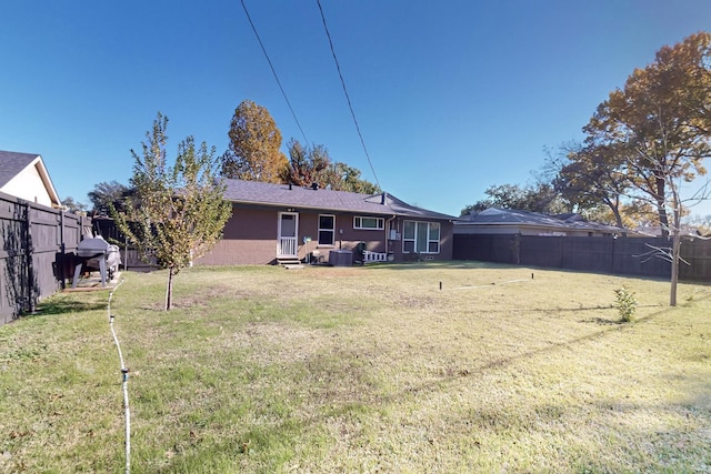 rear view of property with a lawn