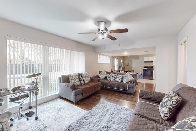 living room featuring ceiling fan and dark wood-type flooring