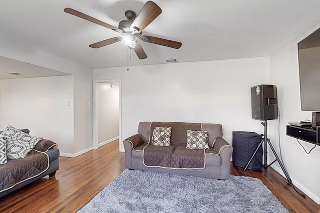 living room featuring dark hardwood / wood-style flooring and ceiling fan