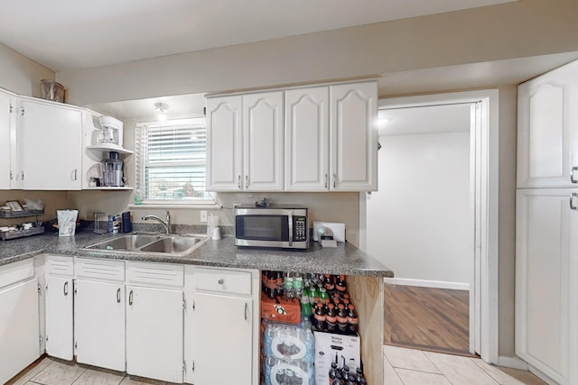 kitchen featuring white cabinetry, sink, and light wood-type flooring