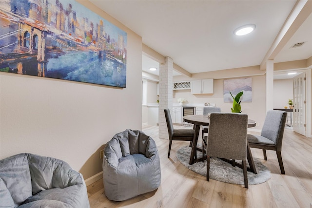 dining room featuring wine cooler and light hardwood / wood-style flooring