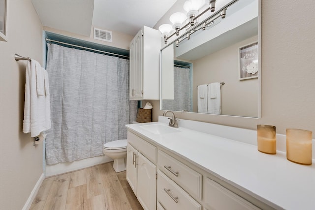 bathroom with vanity, hardwood / wood-style flooring, toilet, and walk in shower