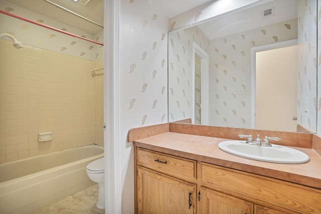 full bathroom with tiled shower / bath combo, vanity, and toilet