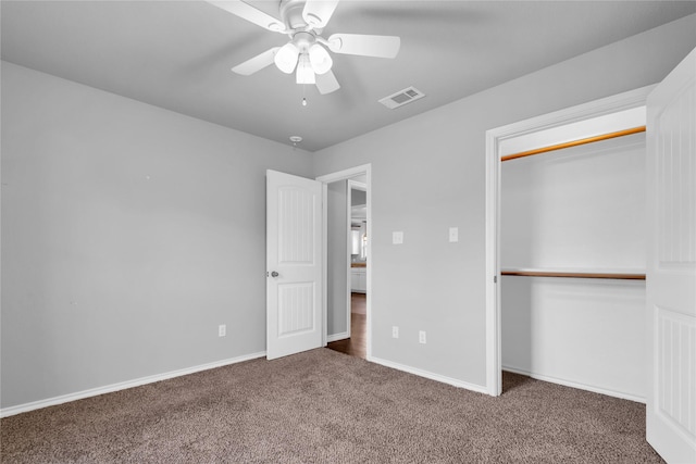 unfurnished bedroom featuring ceiling fan, dark carpet, and a closet