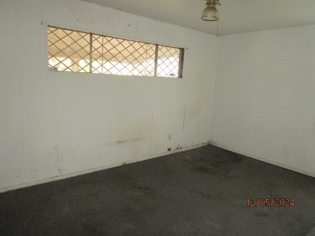 spare room featuring dark colored carpet