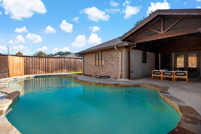 view of swimming pool featuring a patio area and french doors