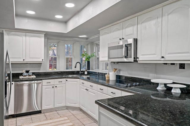 kitchen featuring white cabinets, a raised ceiling, sink, appliances with stainless steel finishes, and light tile patterned flooring