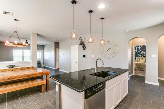 kitchen featuring white cabinetry, sink, stainless steel dishwasher, and decorative light fixtures