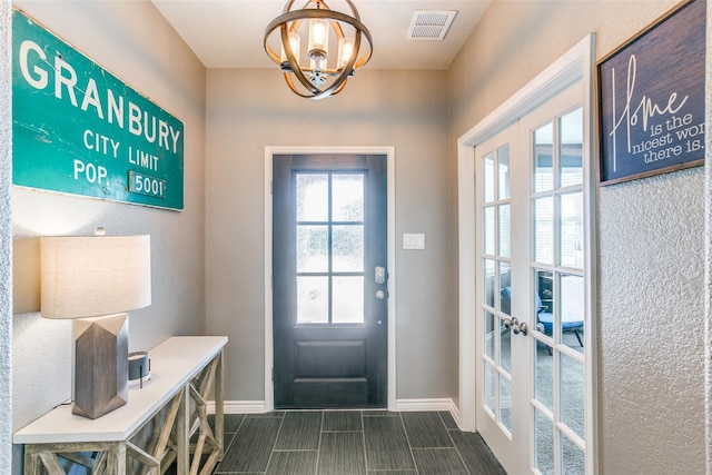 doorway with french doors and a chandelier