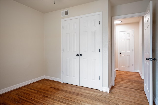 unfurnished bedroom featuring a closet and light hardwood / wood-style floors