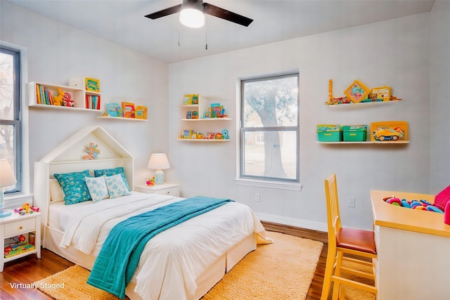 bedroom featuring hardwood / wood-style floors, ceiling fan, and multiple windows