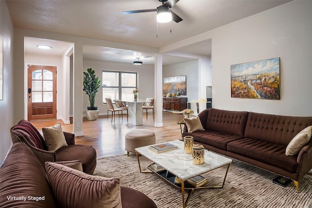 living room with ceiling fan and light hardwood / wood-style flooring