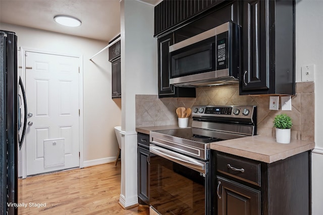 kitchen featuring decorative backsplash, appliances with stainless steel finishes, and light hardwood / wood-style flooring