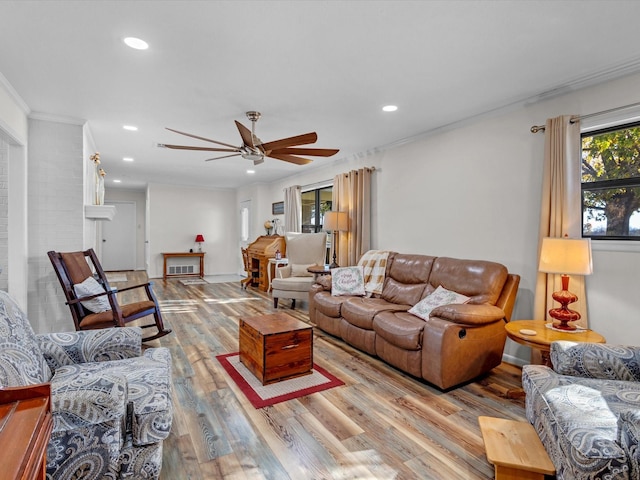 living room featuring ornamental molding, ceiling fan, and light wood-type flooring