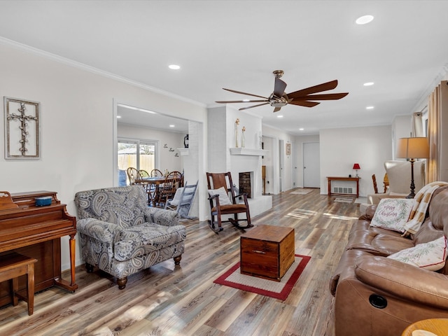 living room featuring hardwood / wood-style floors, crown molding, and ceiling fan