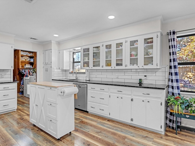 kitchen with crown molding, stainless steel dishwasher, white cabinets, and a kitchen island