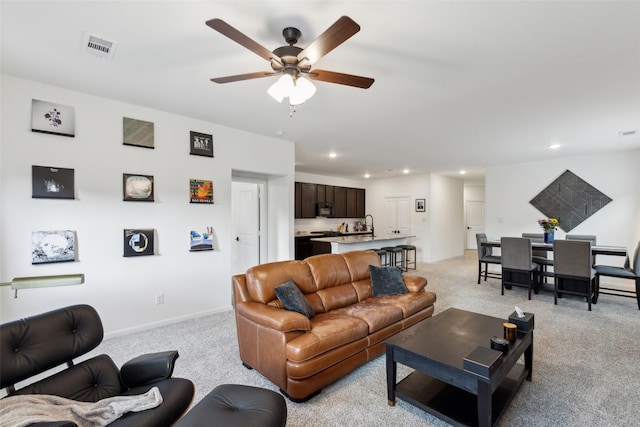 living room featuring light carpet and ceiling fan