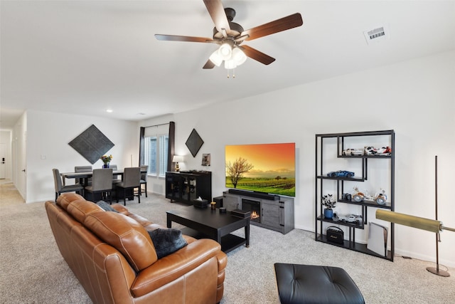 carpeted living room featuring ceiling fan