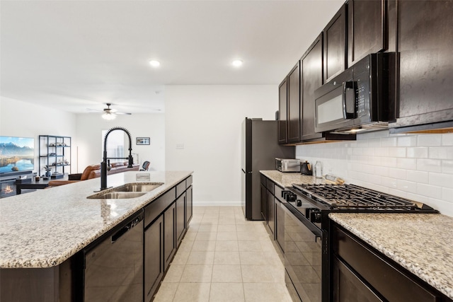 kitchen with a kitchen island with sink, sink, ceiling fan, light tile patterned floors, and appliances with stainless steel finishes