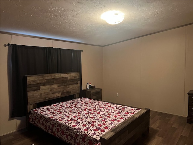 bedroom with a textured ceiling and dark hardwood / wood-style flooring