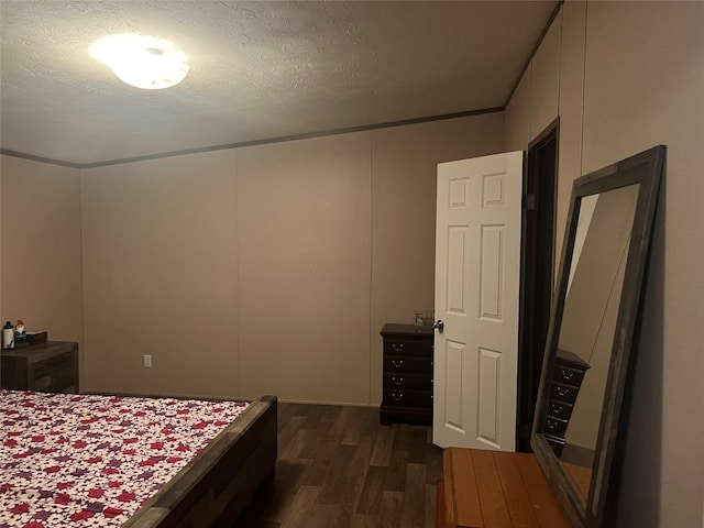 bedroom with dark hardwood / wood-style floors and a textured ceiling