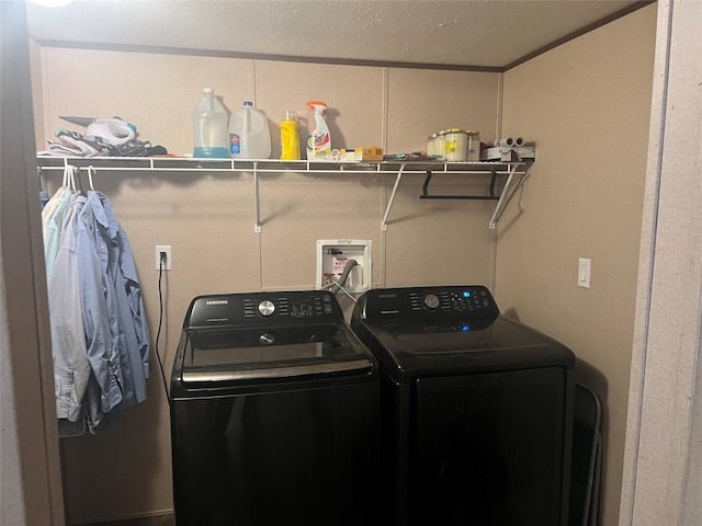 laundry area with crown molding, washing machine and dryer, and a textured ceiling