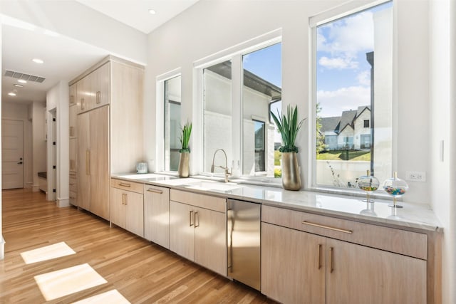 kitchen featuring refrigerator, sink, and light brown cabinets