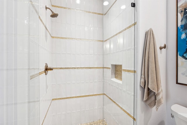 bathroom with toilet and tiled shower