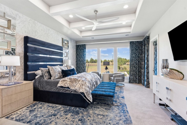 carpeted bedroom featuring a tray ceiling and ceiling fan