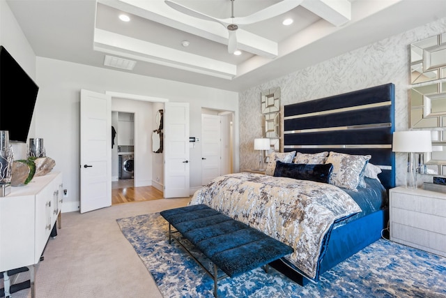 carpeted bedroom featuring beam ceiling, washer / dryer, a tray ceiling, and ceiling fan