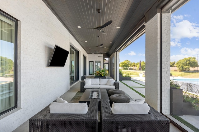 view of patio with an outdoor living space and ceiling fan