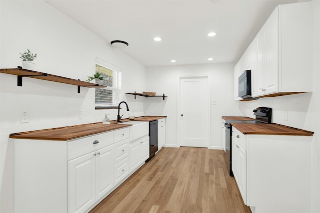 kitchen featuring white cabinetry, black appliances, wooden counters, and light wood-type flooring