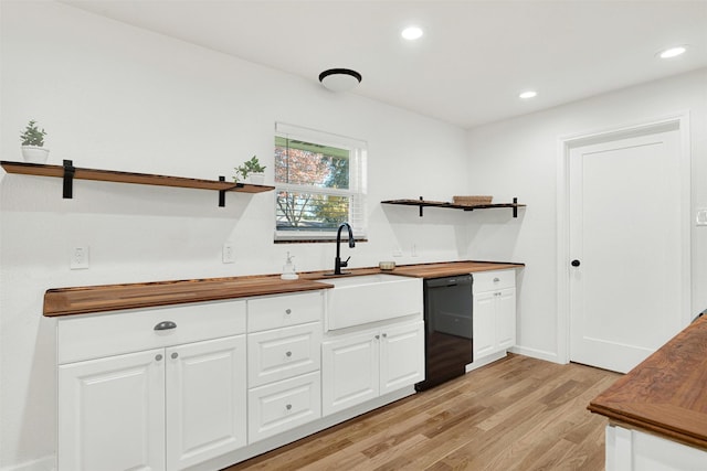 kitchen with butcher block countertops, dishwasher, white cabinets, and light hardwood / wood-style floors